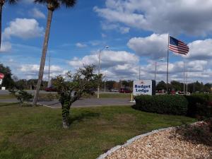 a building with a sign and an american flag at Budget Lodge Mount Dora in Mount Dora
