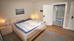 a bedroom with a bed and a walk in shower at Stadtwohnung zur großen Buche, EG in Leer