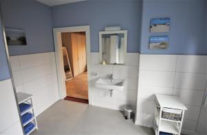 a bathroom with a sink and a mirror at Stadtwohnung zur großen Buche, EG in Leer +4 photos