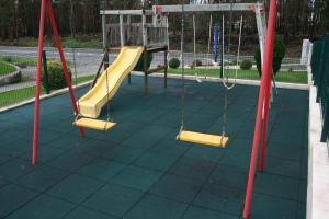 a playground with two swings and a slide at Hotel Padre Cruz in Valença