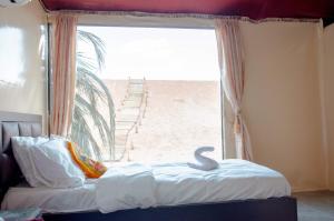a bedroom with a bed with a view of the beach at Arena Desert Camp & Adventurers in Wadi Rum