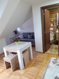 ein Wohnzimmer mit einem weißen Tisch und einem Sofa in der Unterkunft Apartman zlatibor in Zlatibor