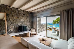 a living room with a couch and a tv at Hotel Milos Sea Resort in Adamas