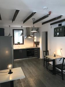 a kitchen with a table and two chairs and a refrigerator at Passpartout Hostel in Timişoara