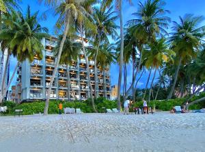 a hotel on the beach with palm trees at Kaani Grand Seaview in Maafushi