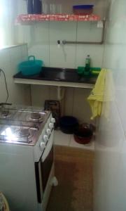 Il comprend une cuisine équipée d'une cuisinière et d'un comptoir. dans l'établissement Apartamento Da Praça, à Arraial do Cabo