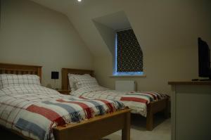 a bedroom with two beds and a window at The Final Furlong, Bruton in Bruton