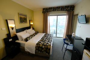 a hotel room with a bed and a window at Royal Court Hotel in Ramallah