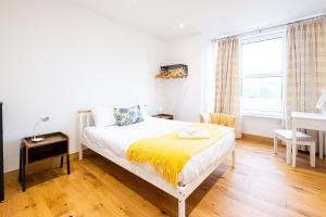 a bedroom with a bed and a desk and a window at Three Tuns Apartments - Ash in Pettistree