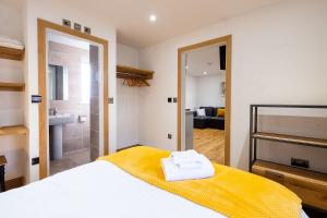 a bedroom with a bed and a bathroom at Three Tuns Apartments - Sycamore in Pettistree