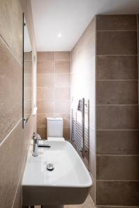 ein Badezimmer mit einem weißen Waschbecken und einem WC in der Unterkunft Three Tuns Apartments - Sycamore in Pettistree
