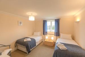 1 dormitorio con 2 camas y ventana en 2 Hazelwood, en Aldringham