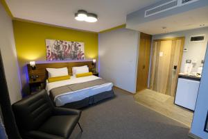1 dormitorio con 1 cama y 1 silla en Royal Court Hotel en Ramallah