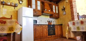 a kitchen with a white refrigerator and a stove at Casa Rural El Colorao in Sotés
