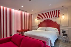 a bedroom with a red bed and a red couch at HOLM Boutique & SPA - IK Collection in St. Julianʼs