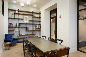 a table in a room with chairs and bookshelves at TRYP by Wyndham Pittsburgh/Lawrenceville in Pittsburgh