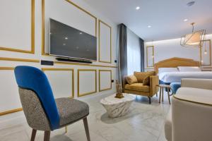 a hotel room with a bedroom with a bed and a tv at HOLM Boutique & SPA - IK Collection in St. Julianʼs