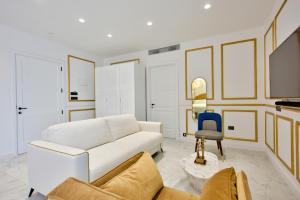 a living room with a white couch and a blue chair at HOLM Boutique & SPA - IK Collection in St. Julianʼs