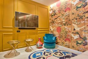 a living room with yellow walls and a tv at HOLM Boutique & SPA - IK Collection in St. Julianʼs