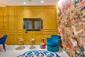 a living room with yellow walls and a tv at HOLM Boutique & SPA - IK Collection in St. Julianʼs