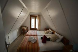 Un dormitorio con dos camas en un ático. en Chalé Acolhedor - Penhas da Saúde - Serra da Estrela, en Covilhã