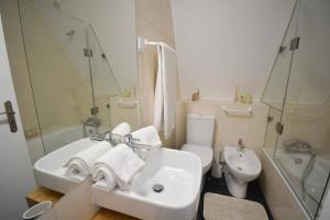 Un baño blanco con lavabo e inodoro. en Chalé Acolhedor - Penhas da Saúde - Serra da Estrela, en Covilhã 21 fotos más