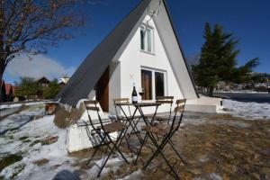 una mesa y sillas frente a una iglesia pequeña en Chalé Acolhedor - Penhas da Saúde - Serra da Estrela, en Covilhã