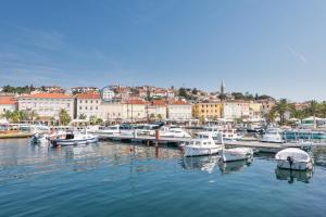 a group of boats docked in a harbor with a city at Apartments Mirakul in Mali Lošinj