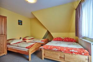 two twin beds in a room with yellow walls at Nędzówka in Ząb