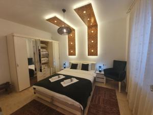 a bedroom with a large bed and a chair at Golden Gate Apartment Sarajevo in Sarajevo