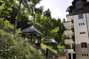 two gazebos on a hill next to a building at Apartamente 13 si 16 in Oxygen Residence Sinaia in Sinaia