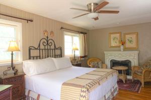 1 dormitorio con 1 cama grande y chimenea en Casa Blanca Inn and Suites en Farmington
