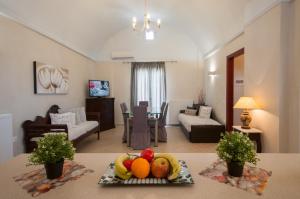 salon ze stołem i talerzem owoców w obiekcie Veldi Art - Kamari Beach Apartment w Firze