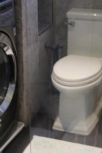 a white toilet in a bathroom next to a washing machine at Master Bedroom-Private Bath, Washington DC in Washington, D.C.