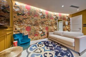 a living room with a couch and a colorful wall at HOLM Boutique & SPA - IK Collection in St. Julianʼs