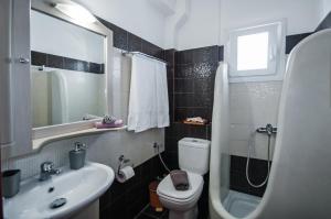 łazienka z umywalką, toaletą i lustrem w obiekcie Veldi Art - Kamari Beach Apartment w Firze +37 zdjęć