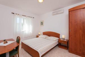 sypialnia z łóżkiem, stołem i biurkiem w obiekcie Apartments Ora - with pool w Orebiciu