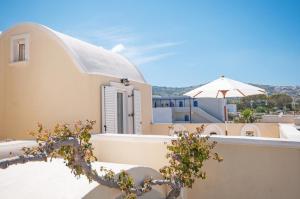 widok na dom z parasolem w obiekcie Veldi Art - Kamari Beach Apartment w Firze