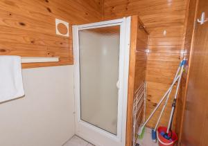 a shower in a bathroom with a glass door at Acacia Cottage in Coles Bay