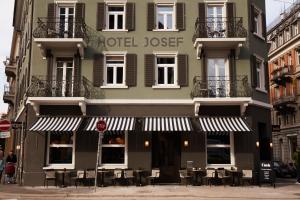 un hotel con tavoli e sedie di fronte a un edificio di Boutique Hotel Josef a Zurigo