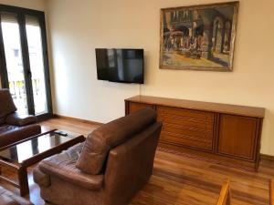 a living room with a couch and a television at Apartaments Vicus 2 con vistas a la Plaza Mayor de Vic in Vic