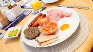 um prato de comida de pequeno-almoço com ovos, bacon, feijão e pão em Kiltearn Guest House em Evanton