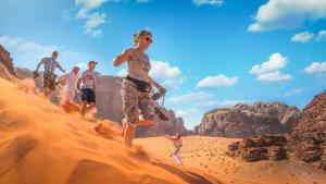 a group of people running in the desert at WadiRum Mobile Camp in Wadi Rum