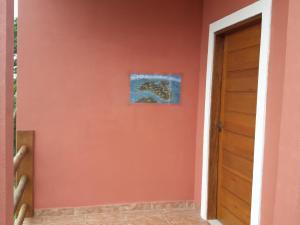 un pasillo con una pared de color naranja y una puerta en Chale Por do Sol, en Ilhabela