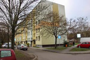 a building on the side of a street with parked cars at NONIEWICZA CENTRUM in Suwałki