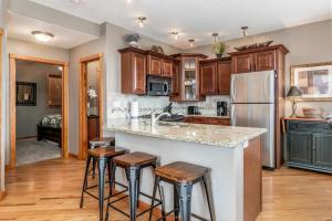 una cucina con armadi in legno e un'isola cucina con sgabelli. di Mount Cirrus 10B Condo a Estes Park Altre 22 foto