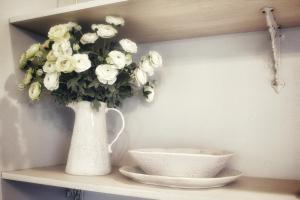a vase with white flowers on a shelf with a bowl at Waterfront Hotel in Prairie du Chien