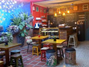 a restaurant with wooden tables and chairs and a counter at Hostal Macondo Inn in Carmen de Viboral