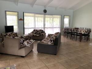 sala de estar con 2 sofás y comedor en Ocean Blue Villas, en Vaimaanga
