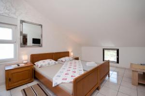 a bedroom with a bed with a table and a mirror at Apartments Drago in Banjole